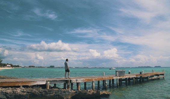 Tom Marchant walking along jetty in Cayman Islands