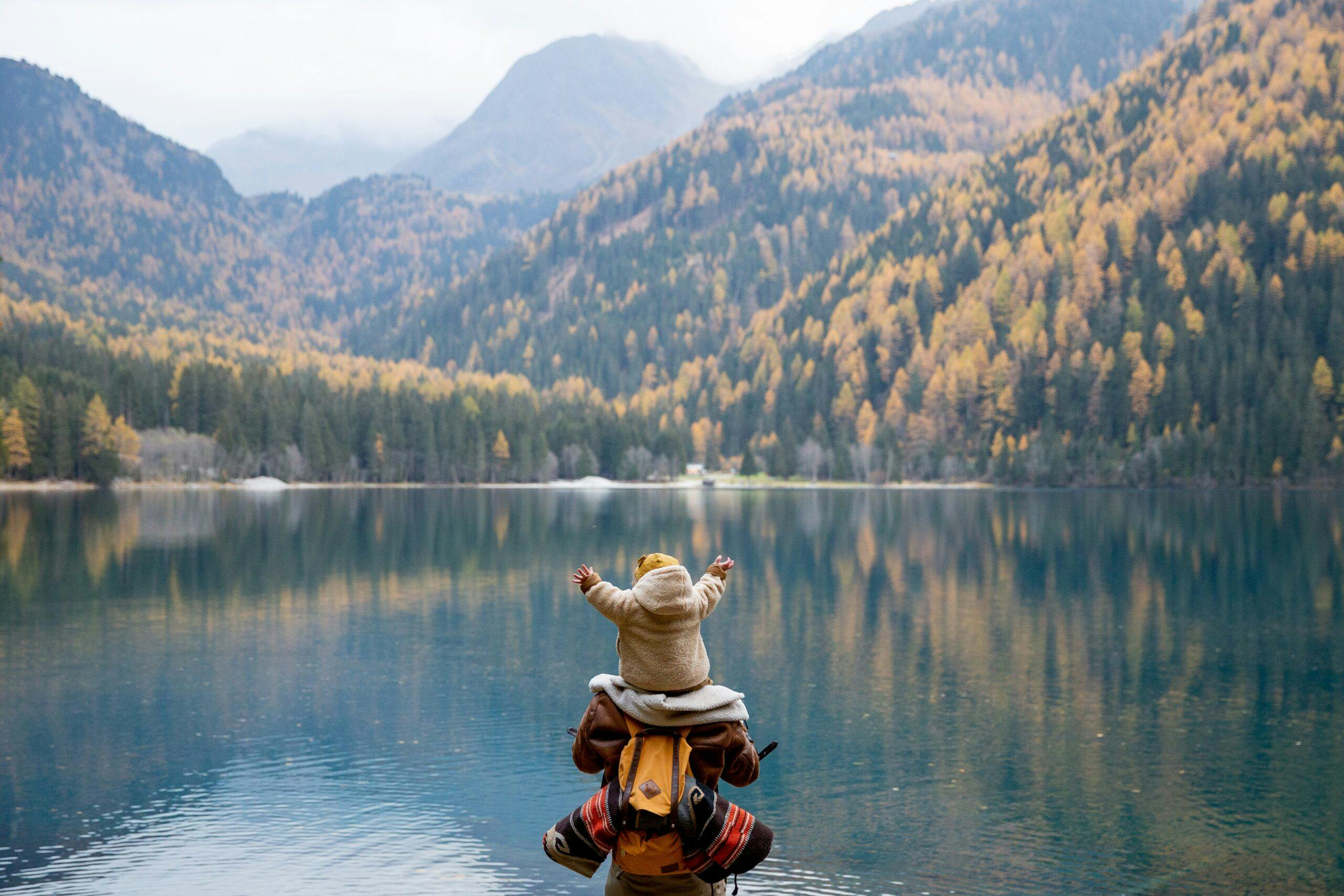 Child balanced on parent's shoulders, luxury family adventure vacations