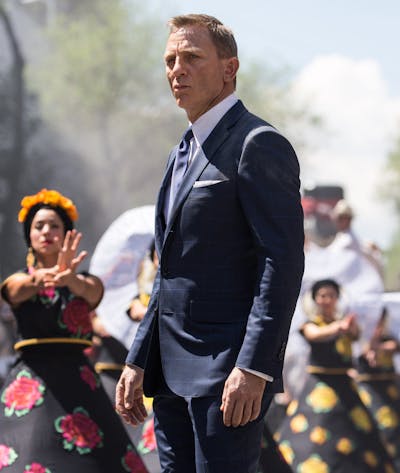 Bond (Daniel Craig) following Marco Sciarra through the Day of the Dead parade; Tolsa Square, Mexico City, Black Tomato